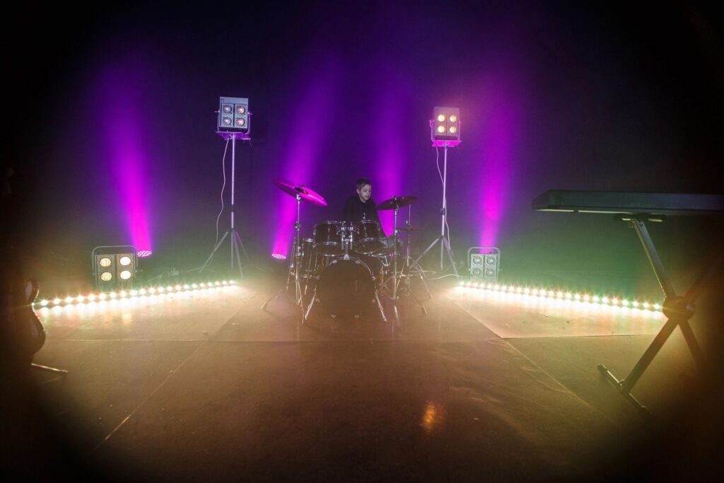 Little drummer behind big set of drums