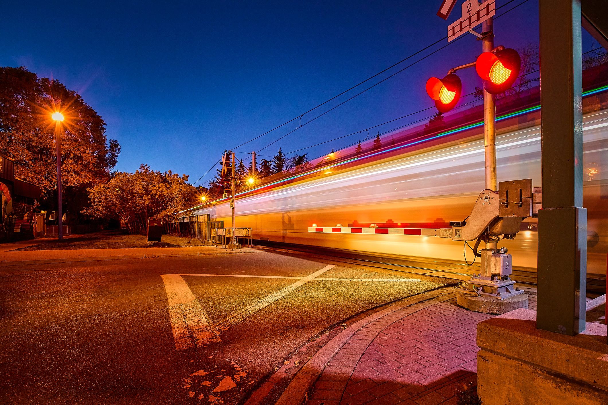 Railway crossing at night with light trails