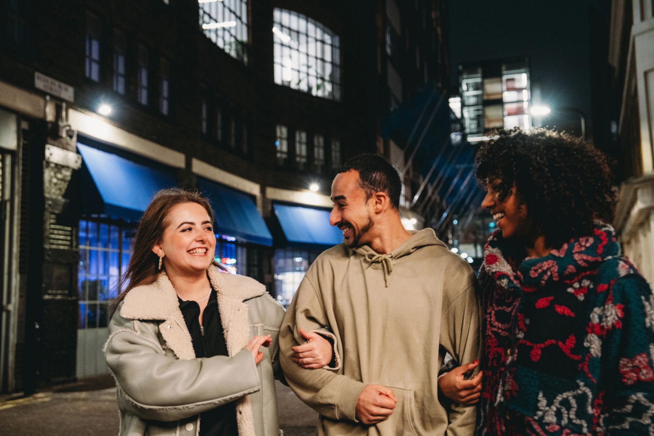 Friends walking together at night in a city street