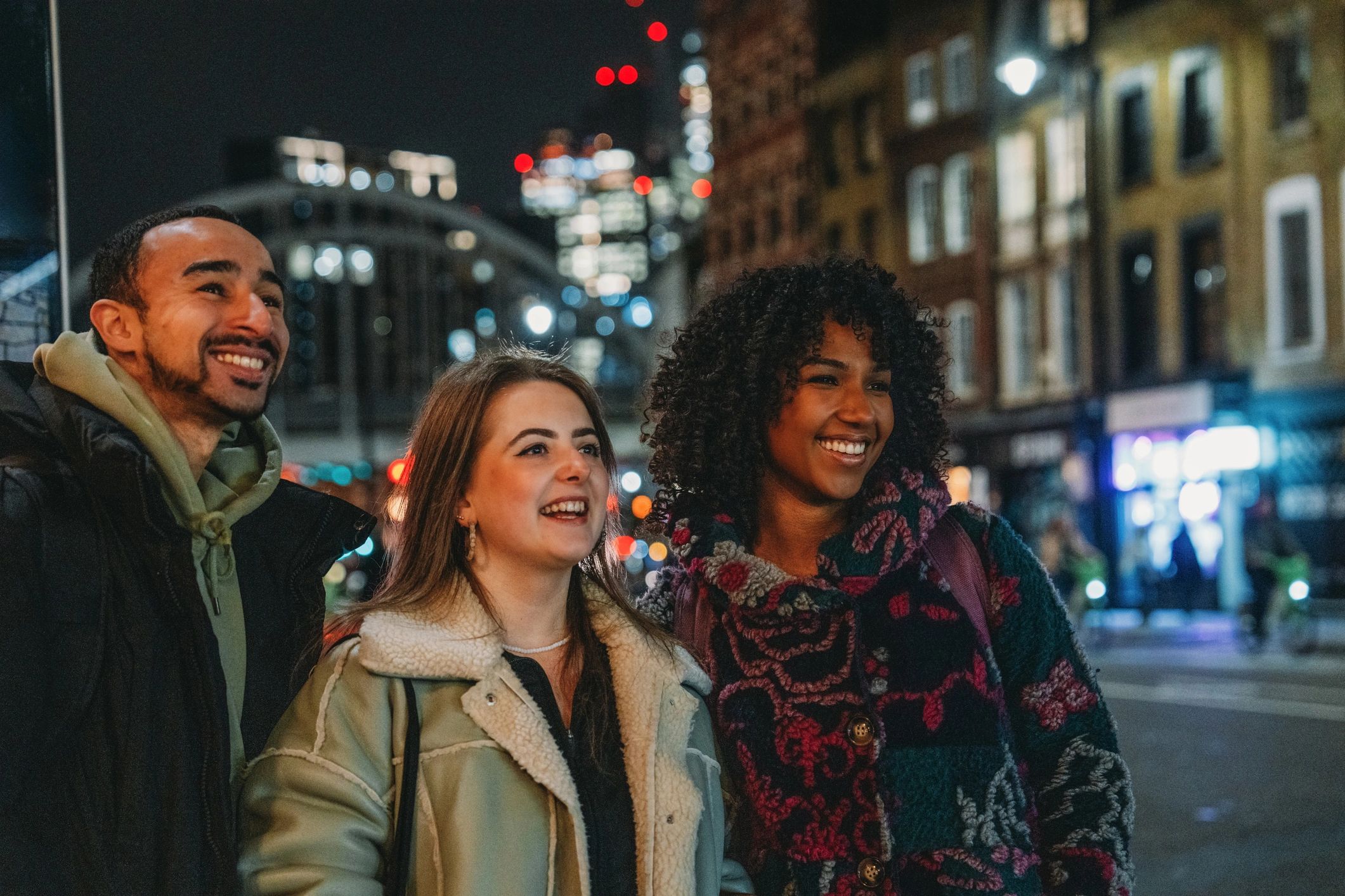 Friends enjoying a city night out with bright skyline lights
