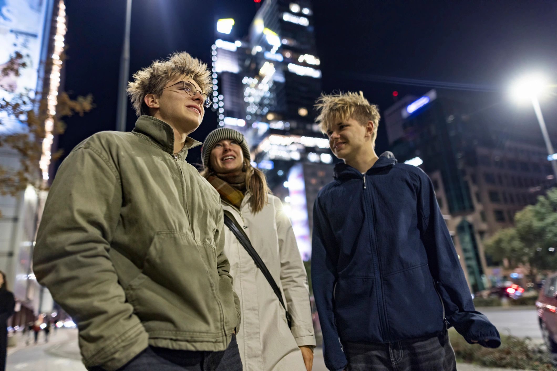 Group walking through a city at night with illuminated buildings
