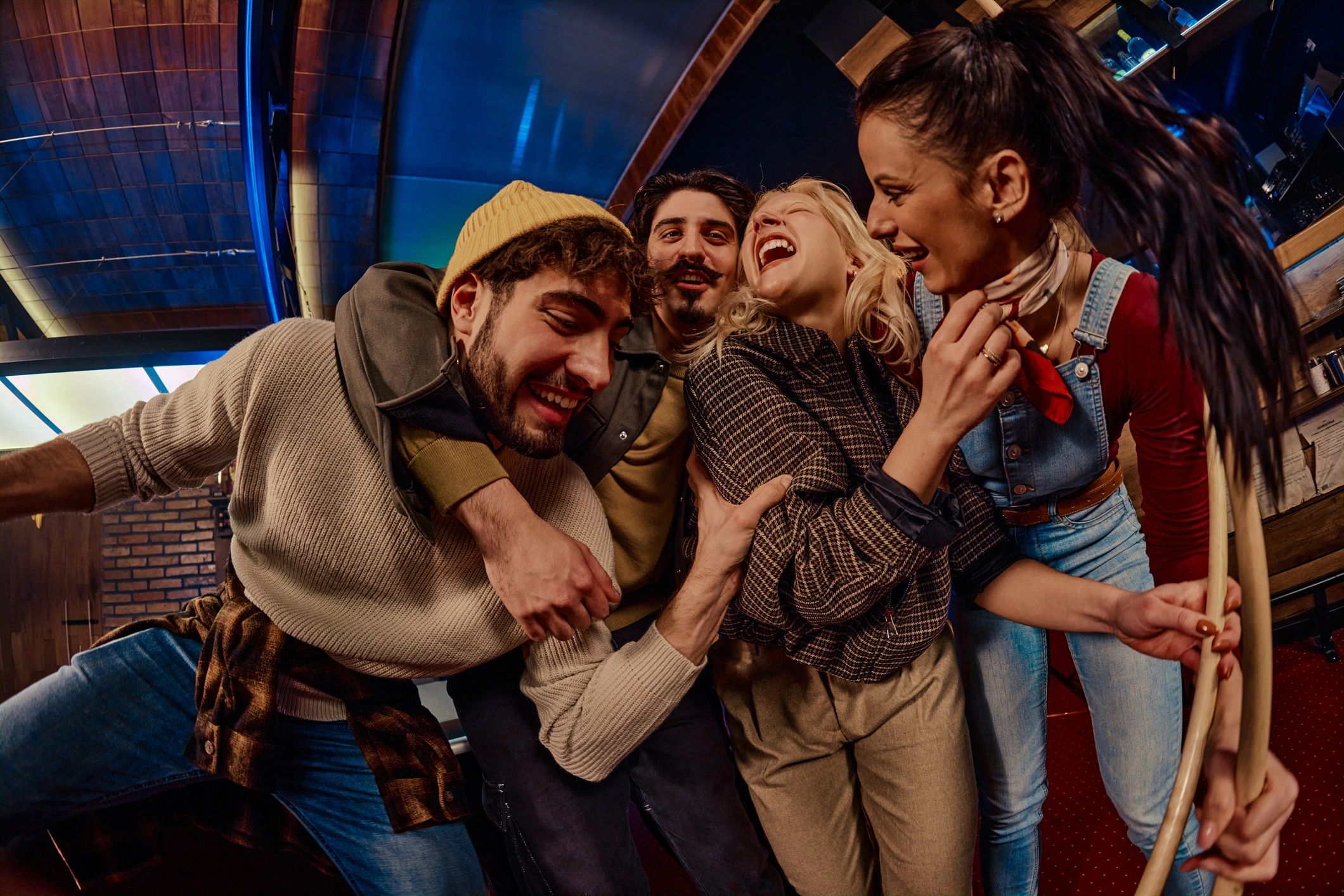 Friends enjoying a lively night out around a game table in a dimly lit venue